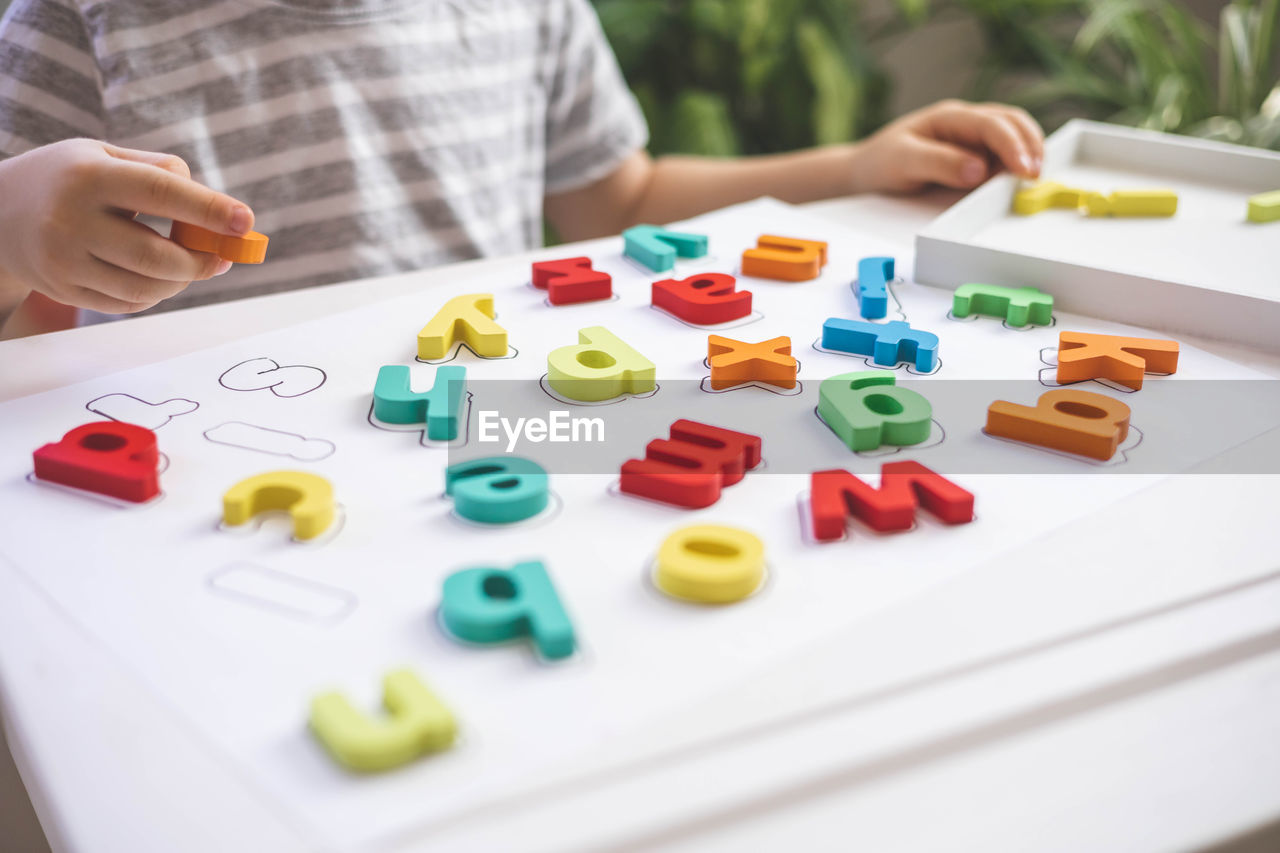 midsection of woman holding toy blocks on table