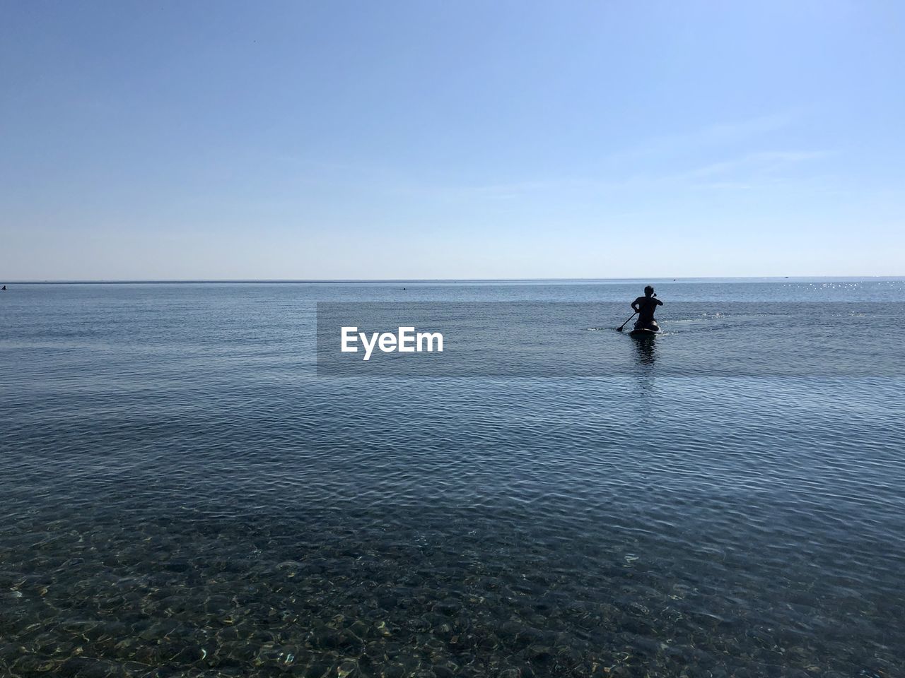 MAN IN SEA AGAINST SKY