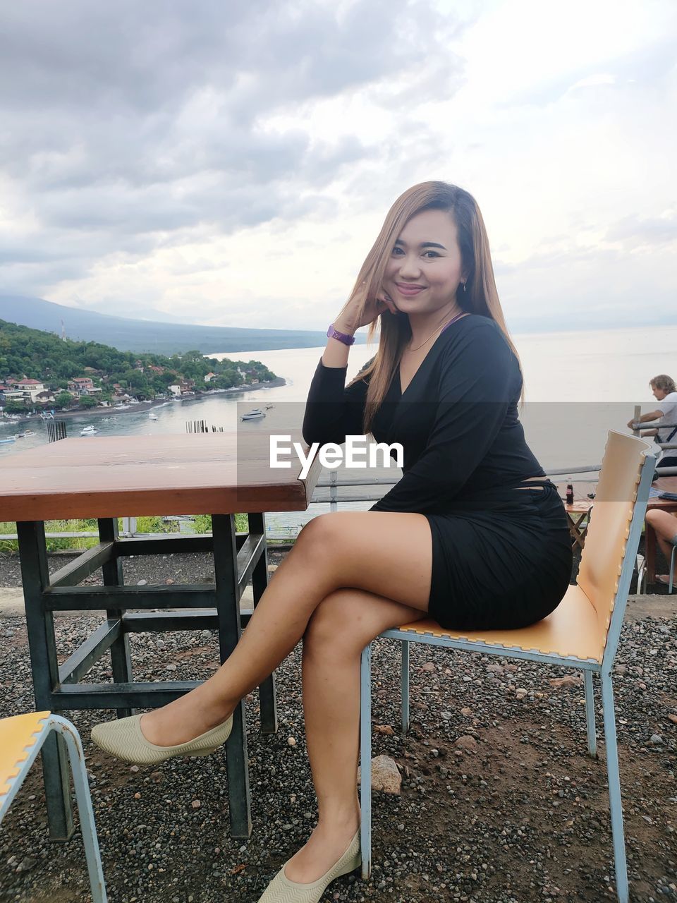 YOUNG WOMAN SITTING ON BENCH