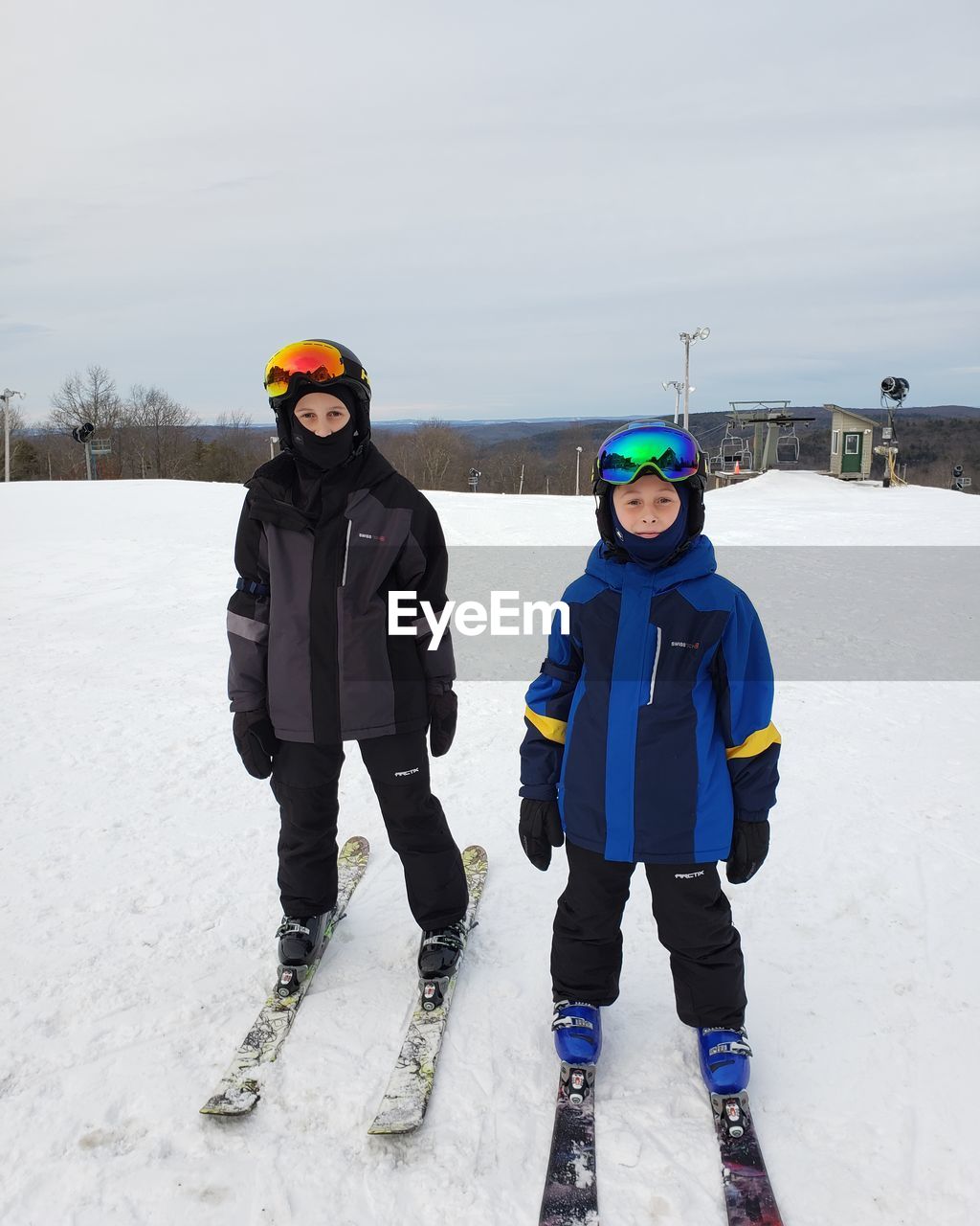 PORTRAIT OF FRIENDS STANDING ON SNOW COVERED LANDSCAPE