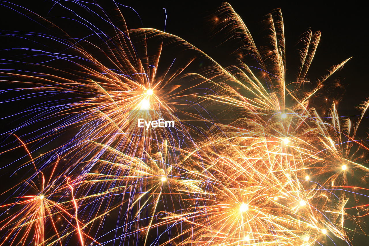 Low angle view of firework display at night