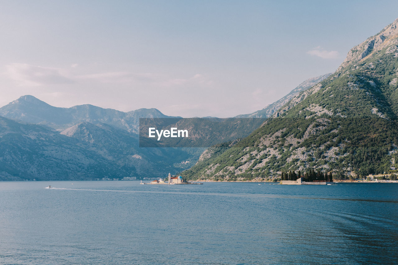 Scenic view of sea and mountains against sky