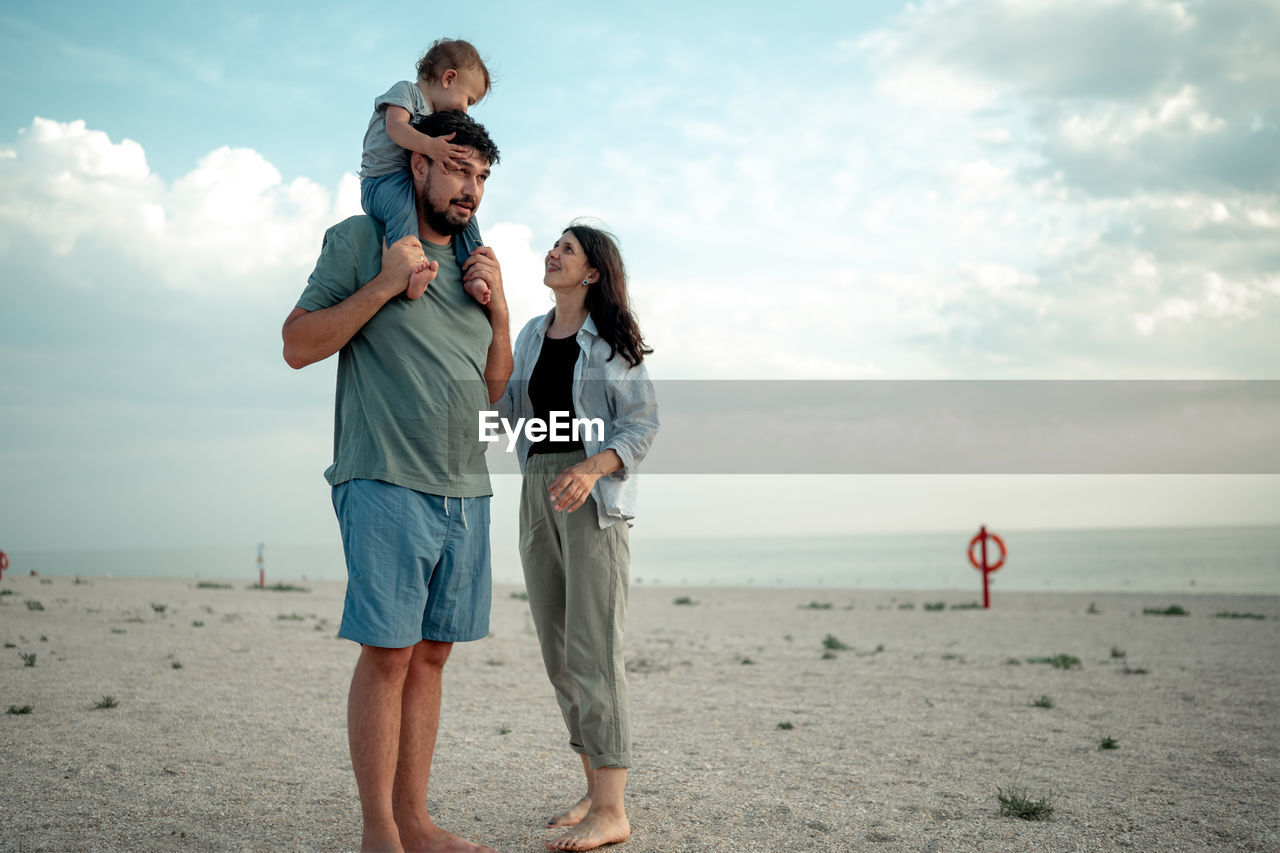 side view of couple standing on beach