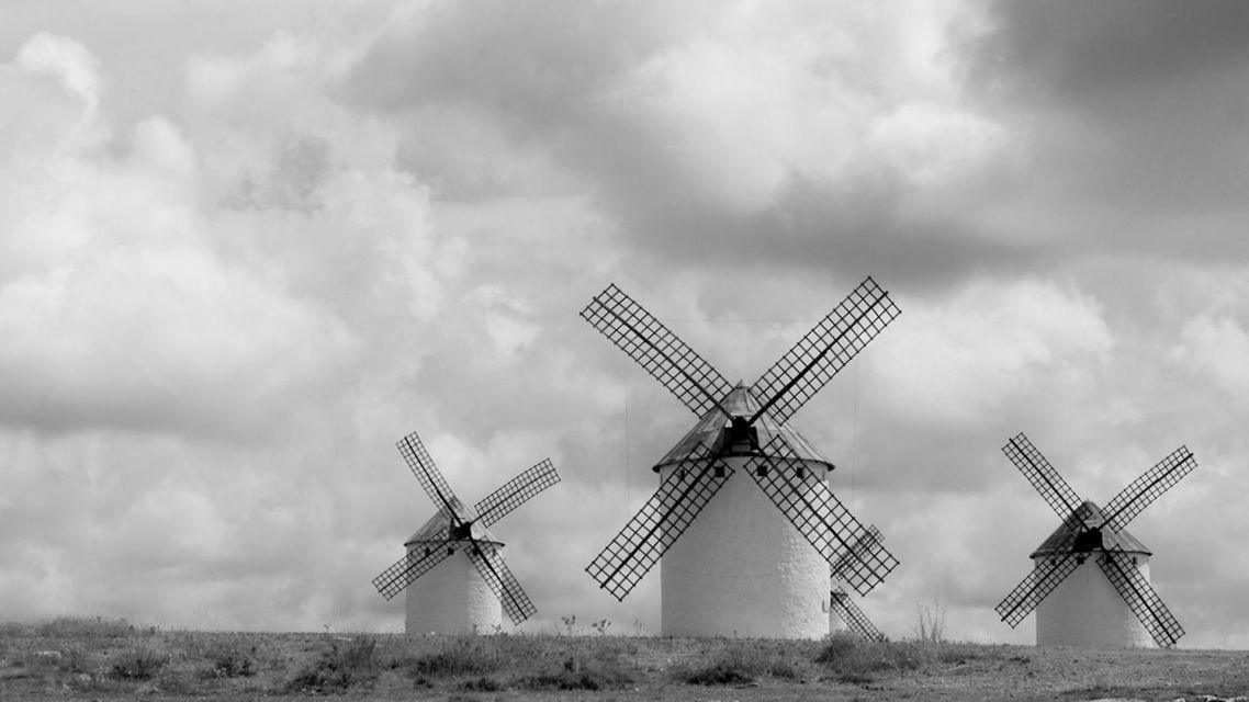 Traditional windmills against cloudy sky