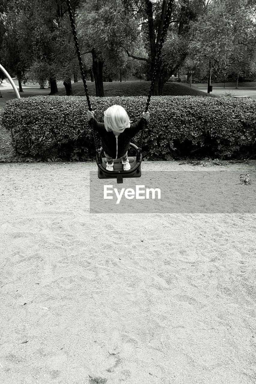 Child playing on swing in park