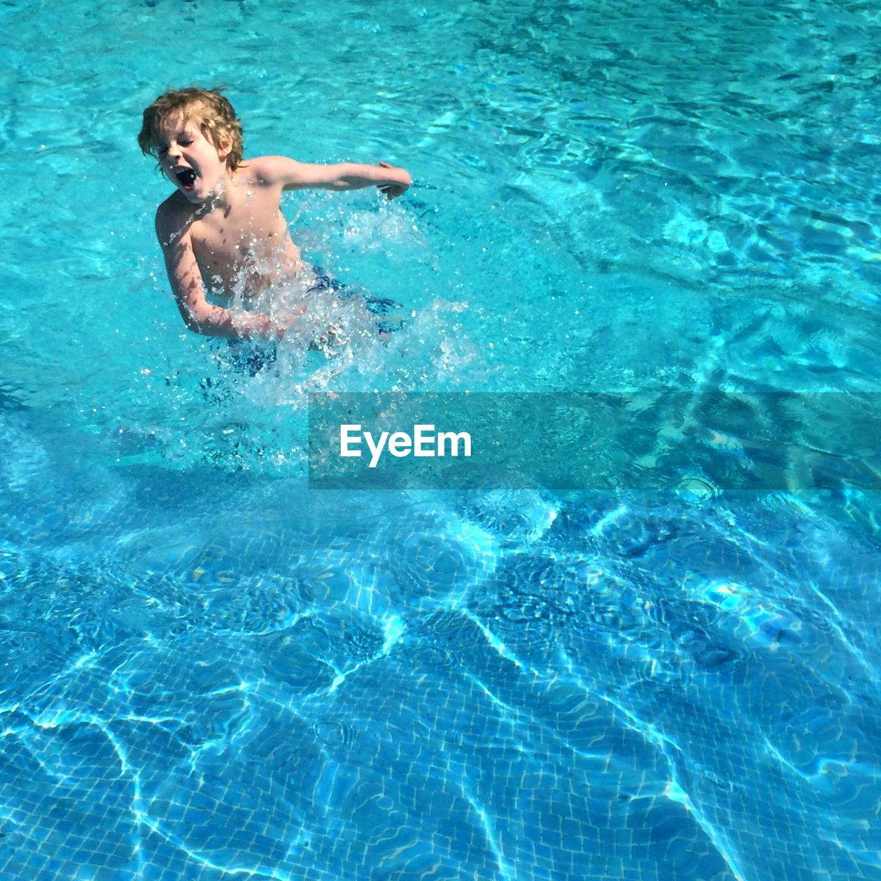 High angle view of boy playing in swimming pool