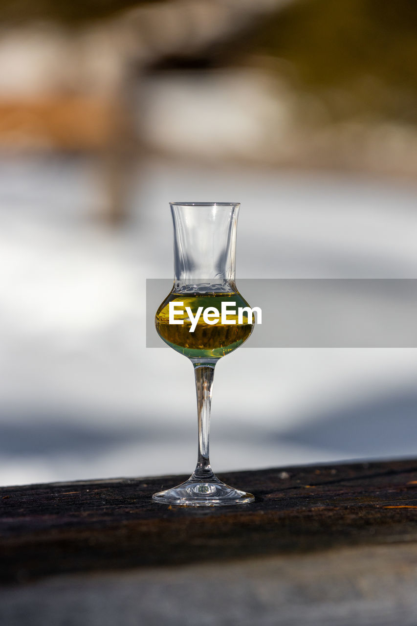 Bokeh picture of a flavored grappa schnapps glass in cortina d'ampezzo, dolomites, italy