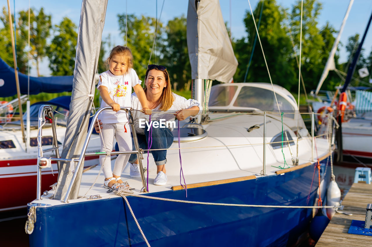 Portrait of mother and daughter sitting on boat