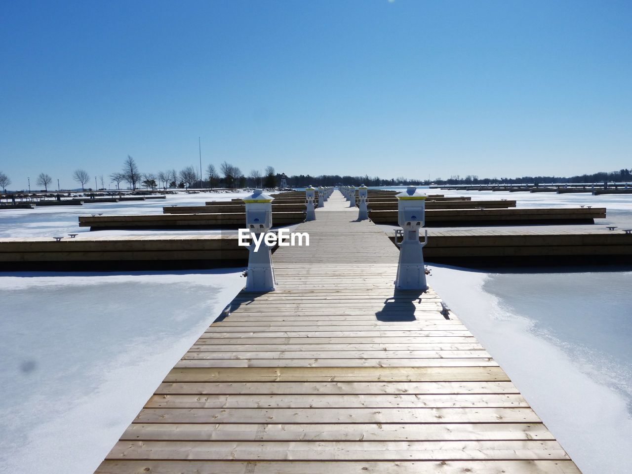 Boardwalk on shore against clear sky