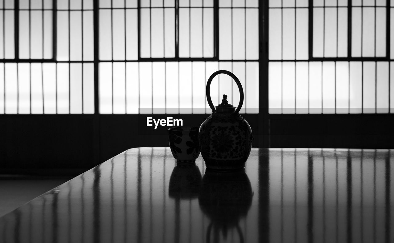 Silhouette of a japanese tea cup and tea kettle in a japanese house.