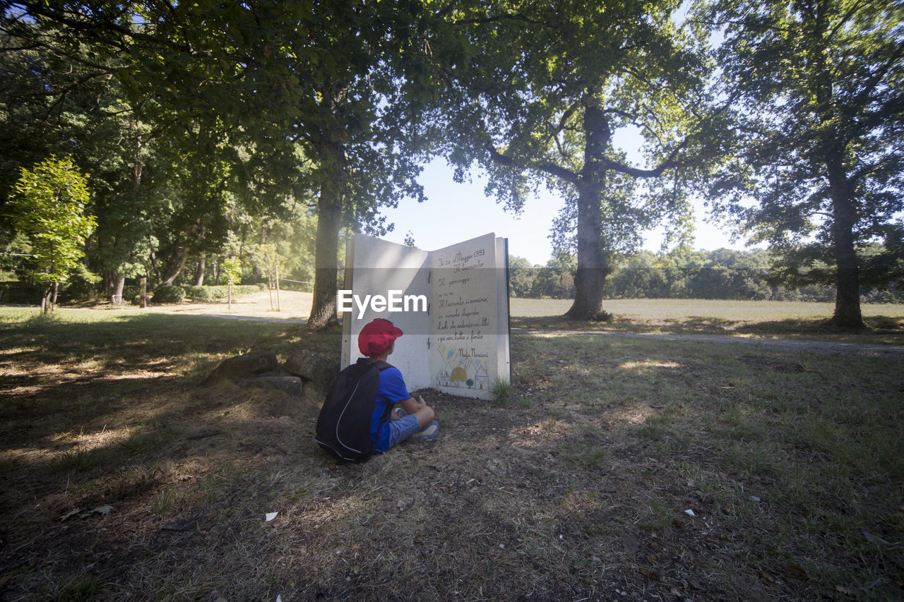 MAN SITTING ON FIELD WITH TEXT