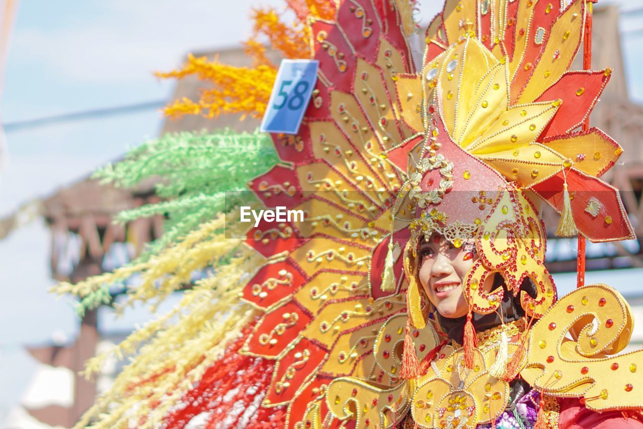 Smiling young woman in costume standing outdoors
