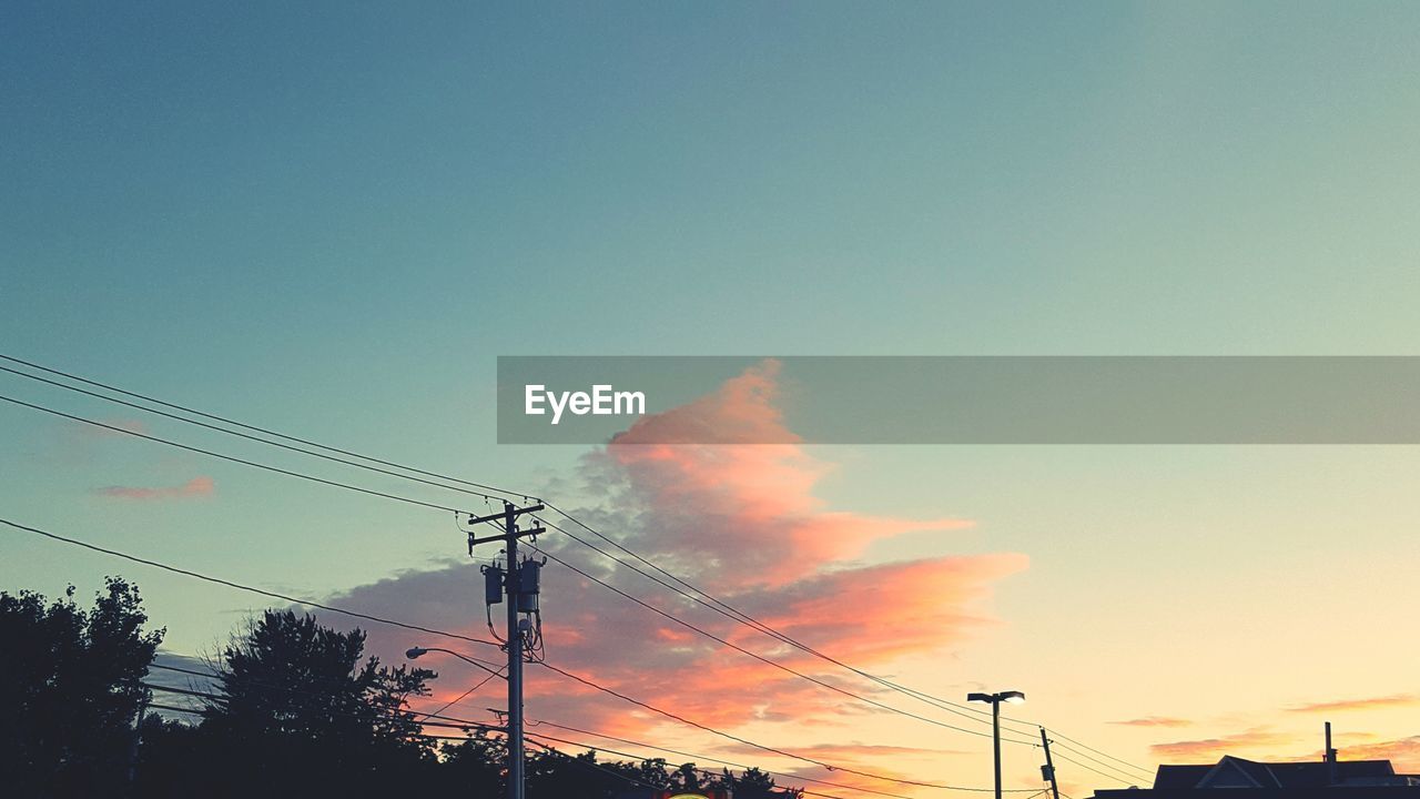 LOW ANGLE VIEW OF ELECTRICITY PYLON AT SUNSET