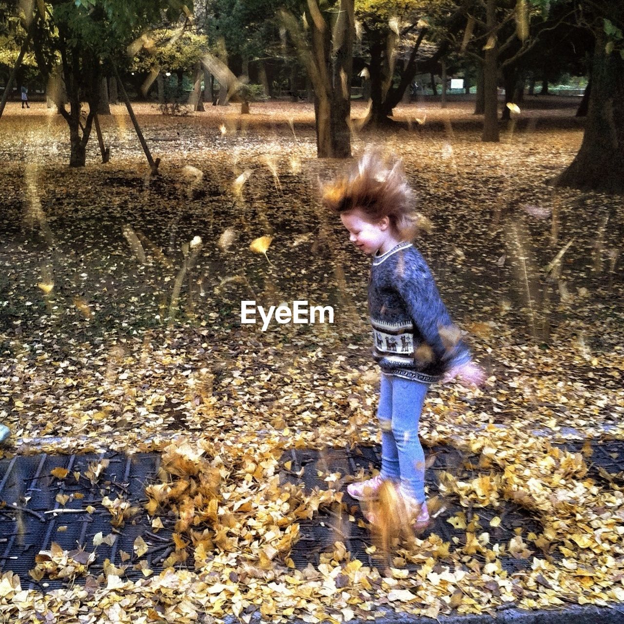 GIRL PLAYING WITH ARMS OUTSTRETCHED IN PARK