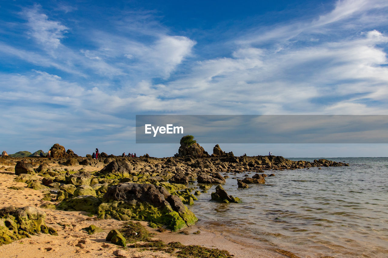 ROCK FORMATION ON SEA AGAINST SKY