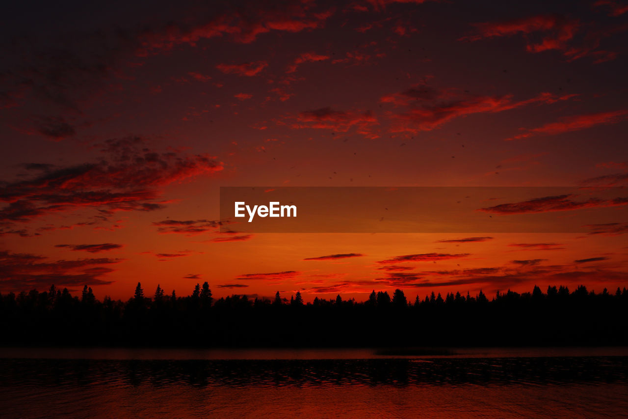 Scenic view of lake against orange sky