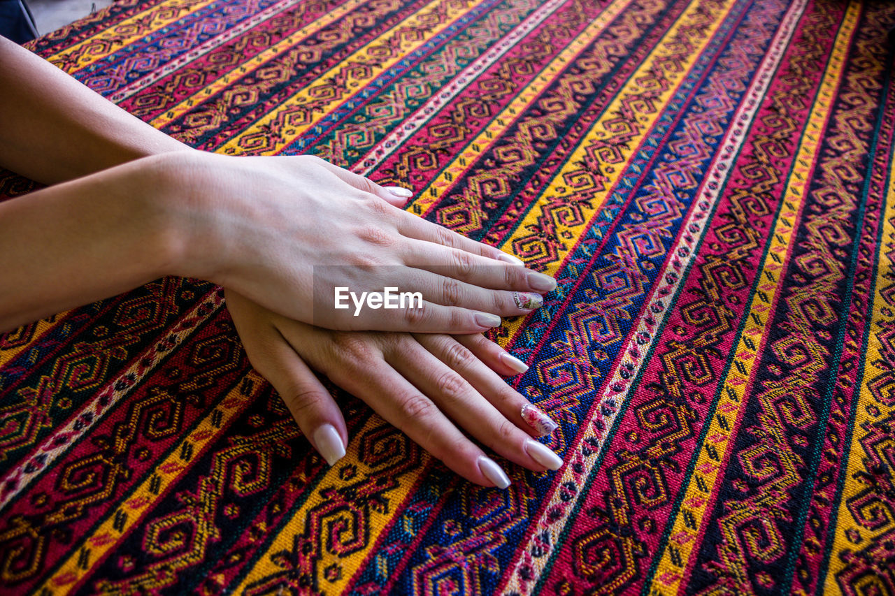 Cropped hands of woman touching patterned fabric