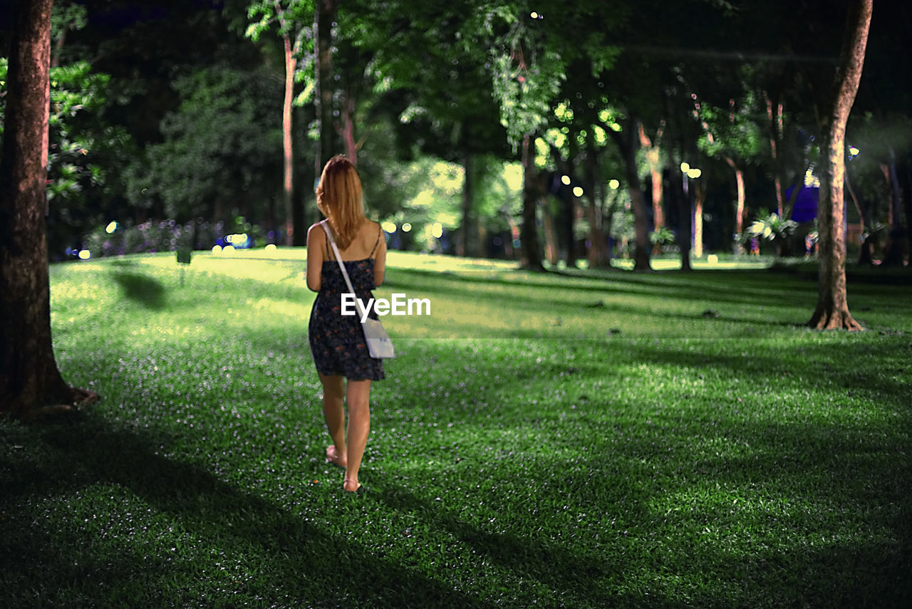 Full length of woman walking in park at night