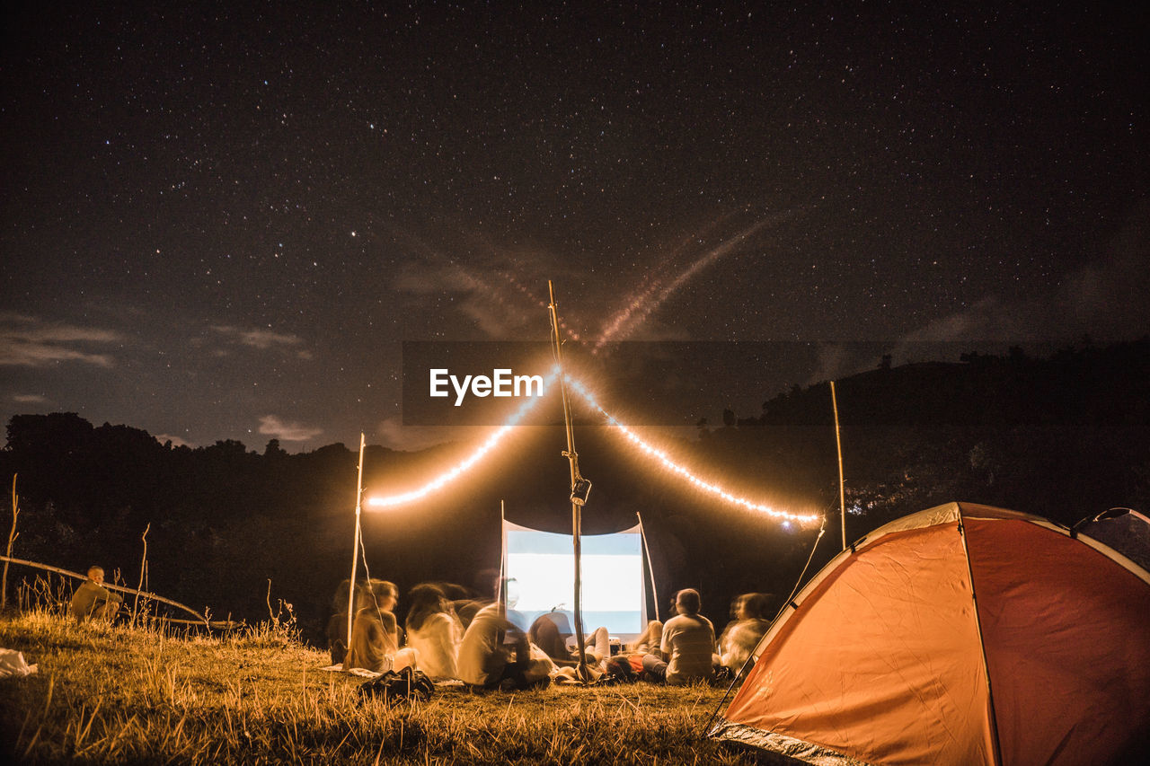 ILLUMINATED TENT ON FIELD AT NIGHT
