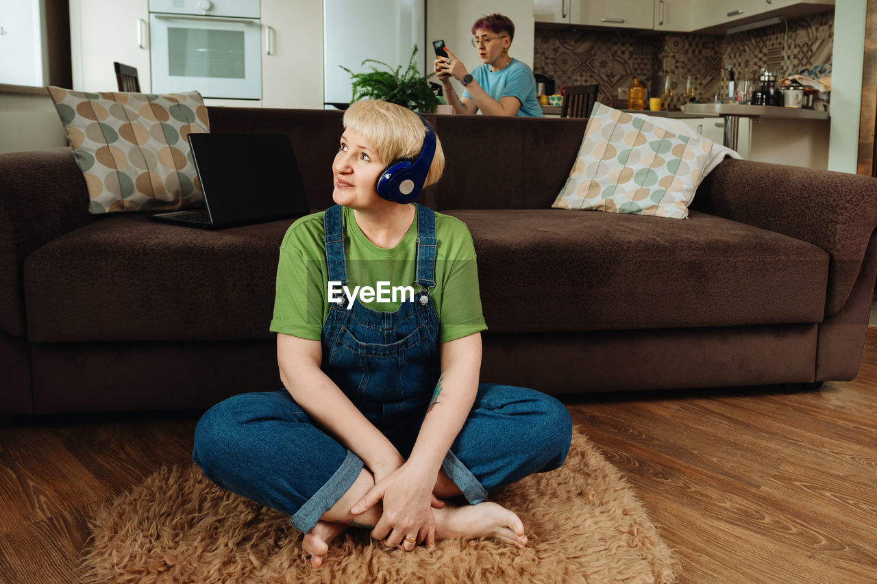 An elderly woman listens to meditation and audio therapy from the living room