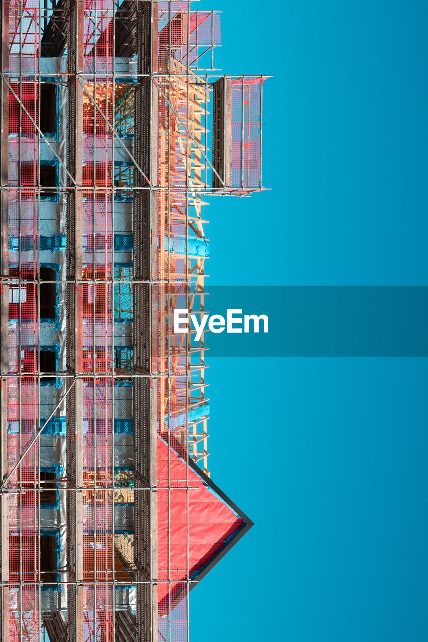 LOW ANGLE VIEW OF BUILDINGS AGAINST BLUE SKY