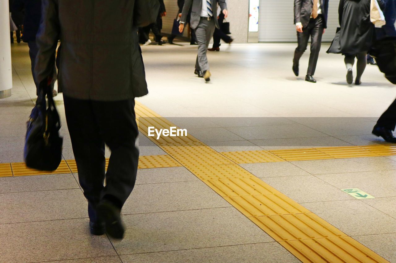 Low section of people walking on subway station