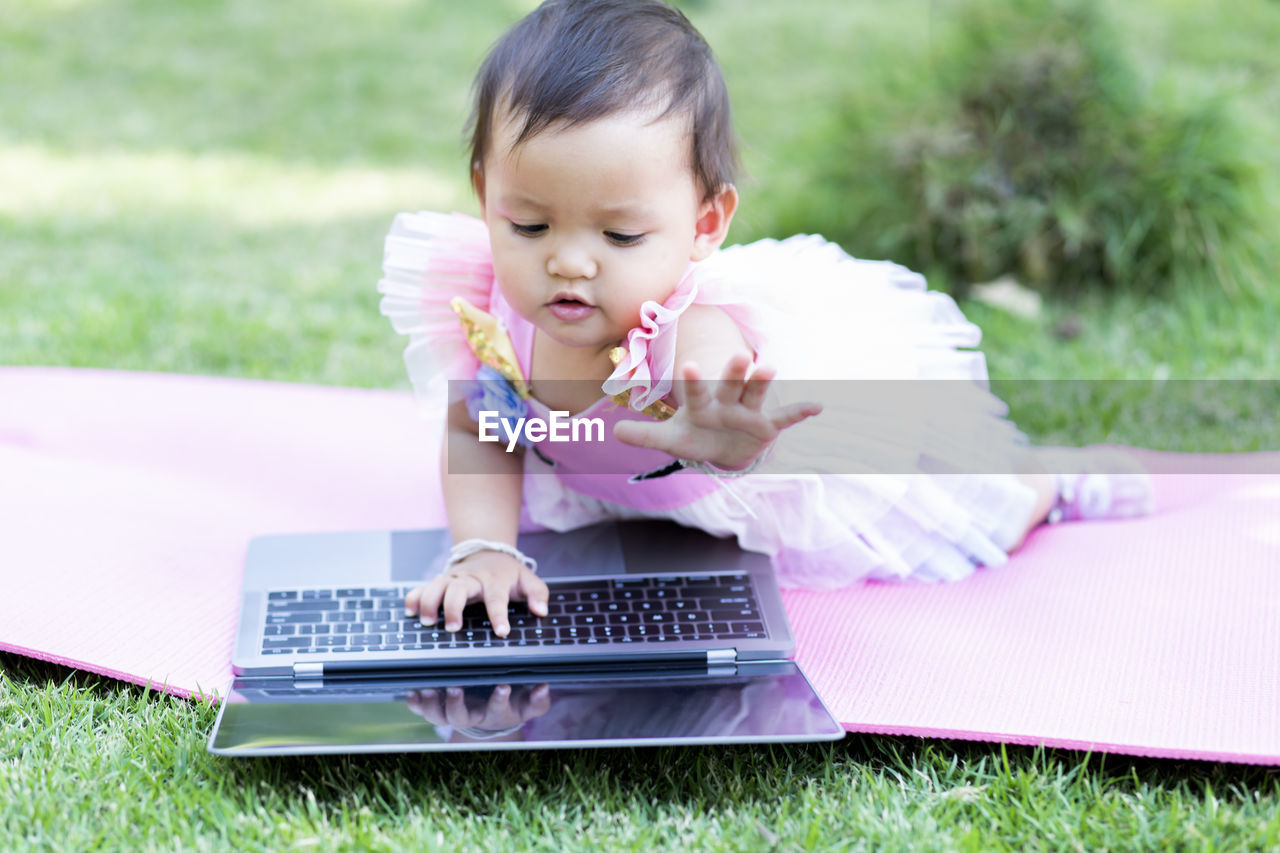 BOY USING PHONE ON GRASS