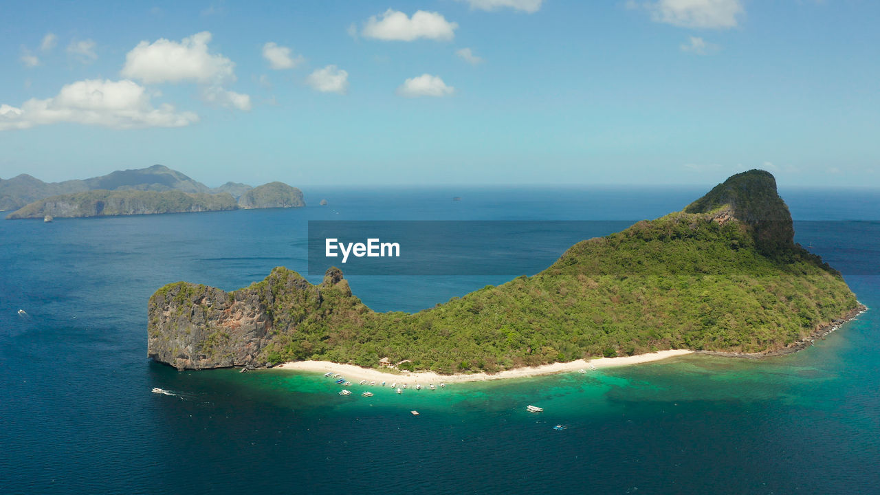 Tropical beach on island with palm trees, blue lagoon and azure clear water. helicopter island 