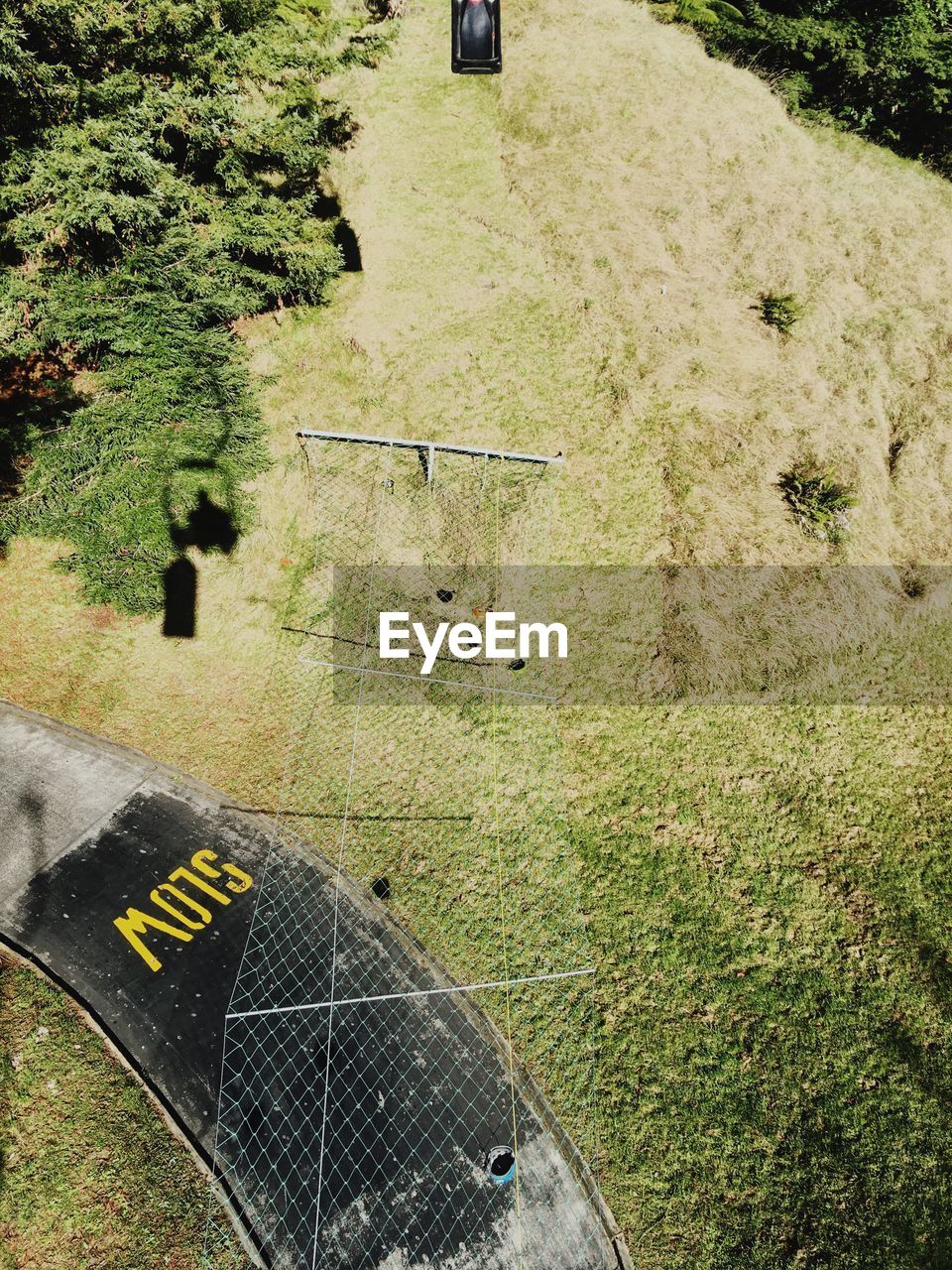 High angle view of net over empty road on grassy field