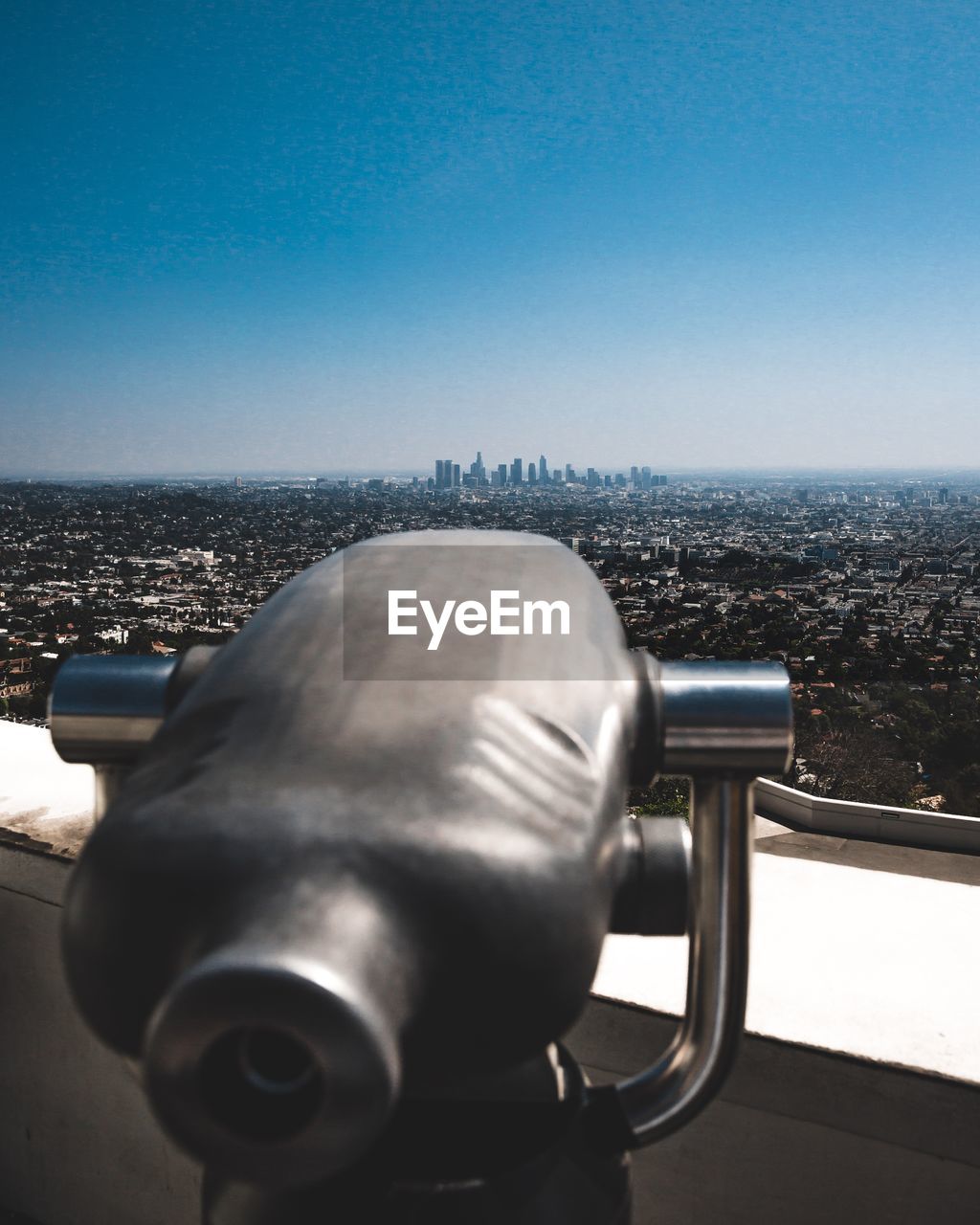 Close-up of coin-operated binoculars against cityscape