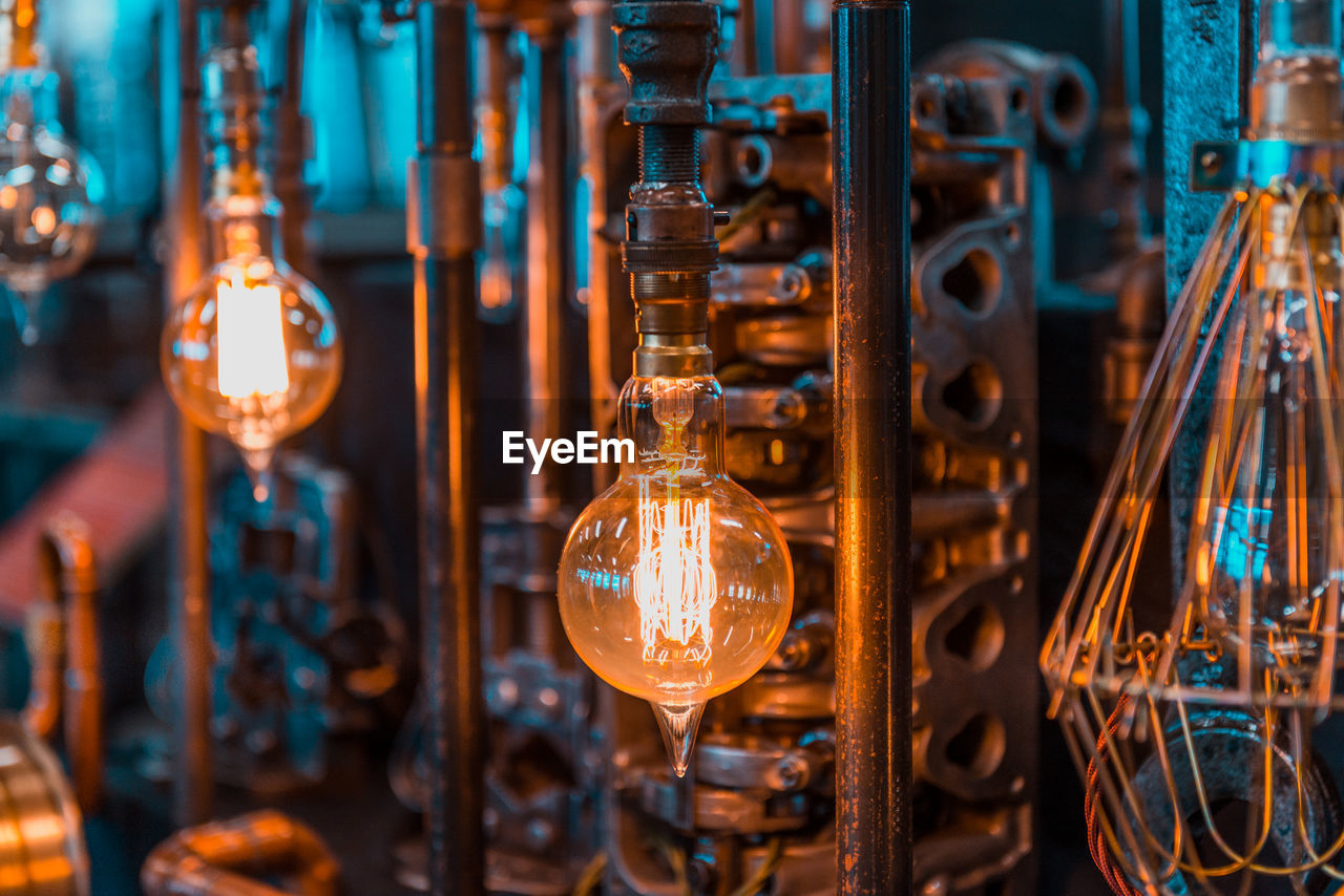 Illuminated light bulbs hanging in factory