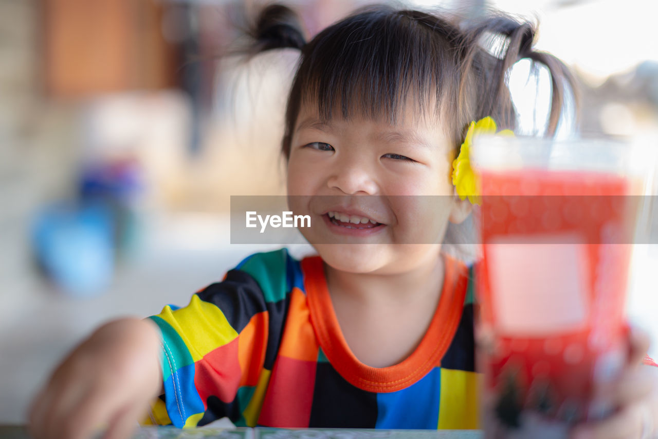 Close-up portrait of girl holding juice