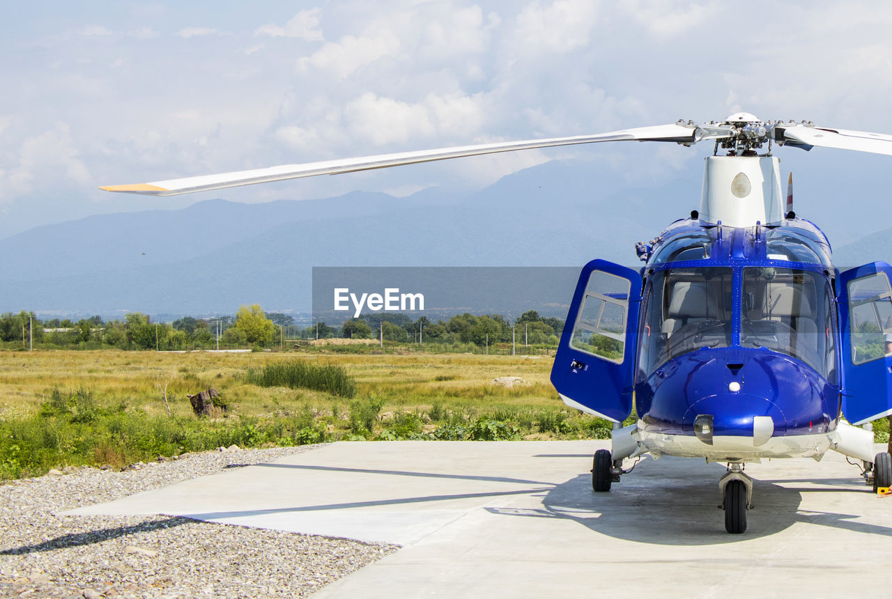 Blue helicopter, view of the plane , sunlight and field