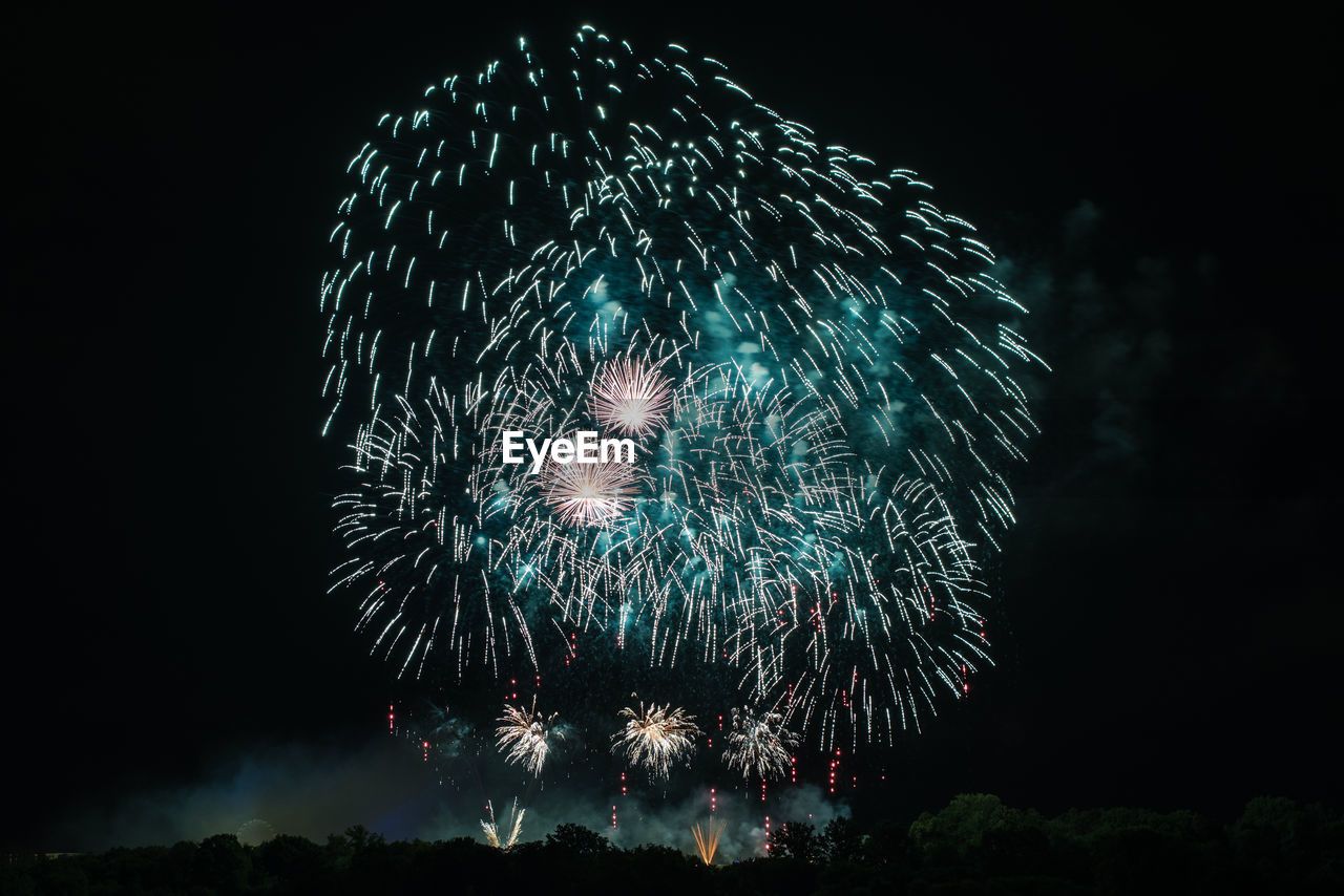 LOW ANGLE VIEW OF FIREWORK DISPLAY AT NIGHT