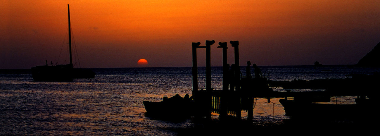 SILHOUETTE SAILBOAT IN SEA AGAINST ORANGE SKY