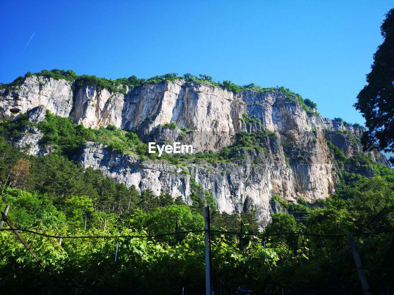 LOW ANGLE VIEW OF ROCK FORMATION AGAINST CLEAR BLUE SKY