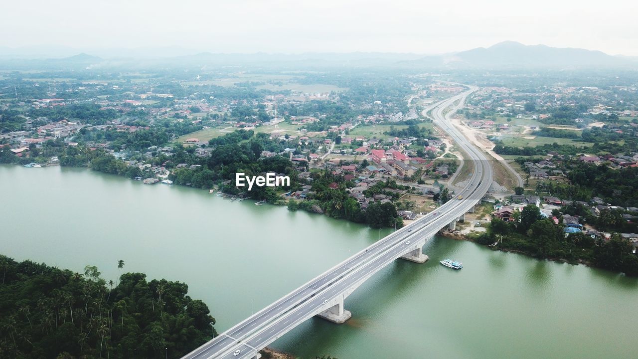 High angle view of river amidst city against sky