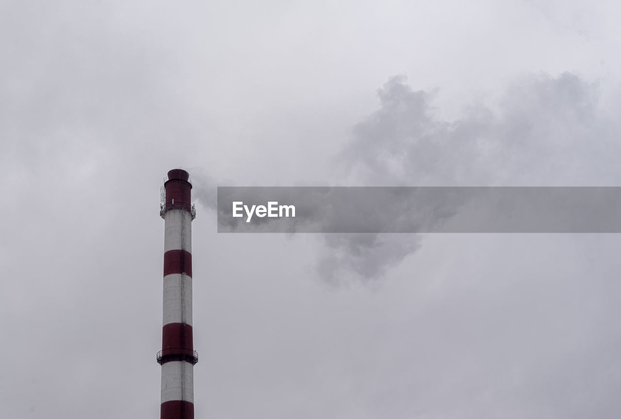 LOW ANGLE VIEW OF SMOKE EMITTING FROM CHIMNEY AGAINST SKY