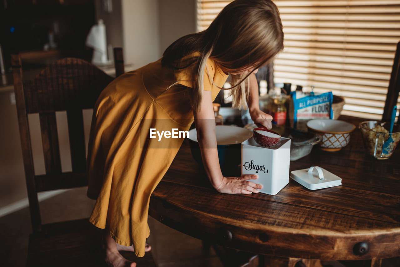 Girl at table preparing food