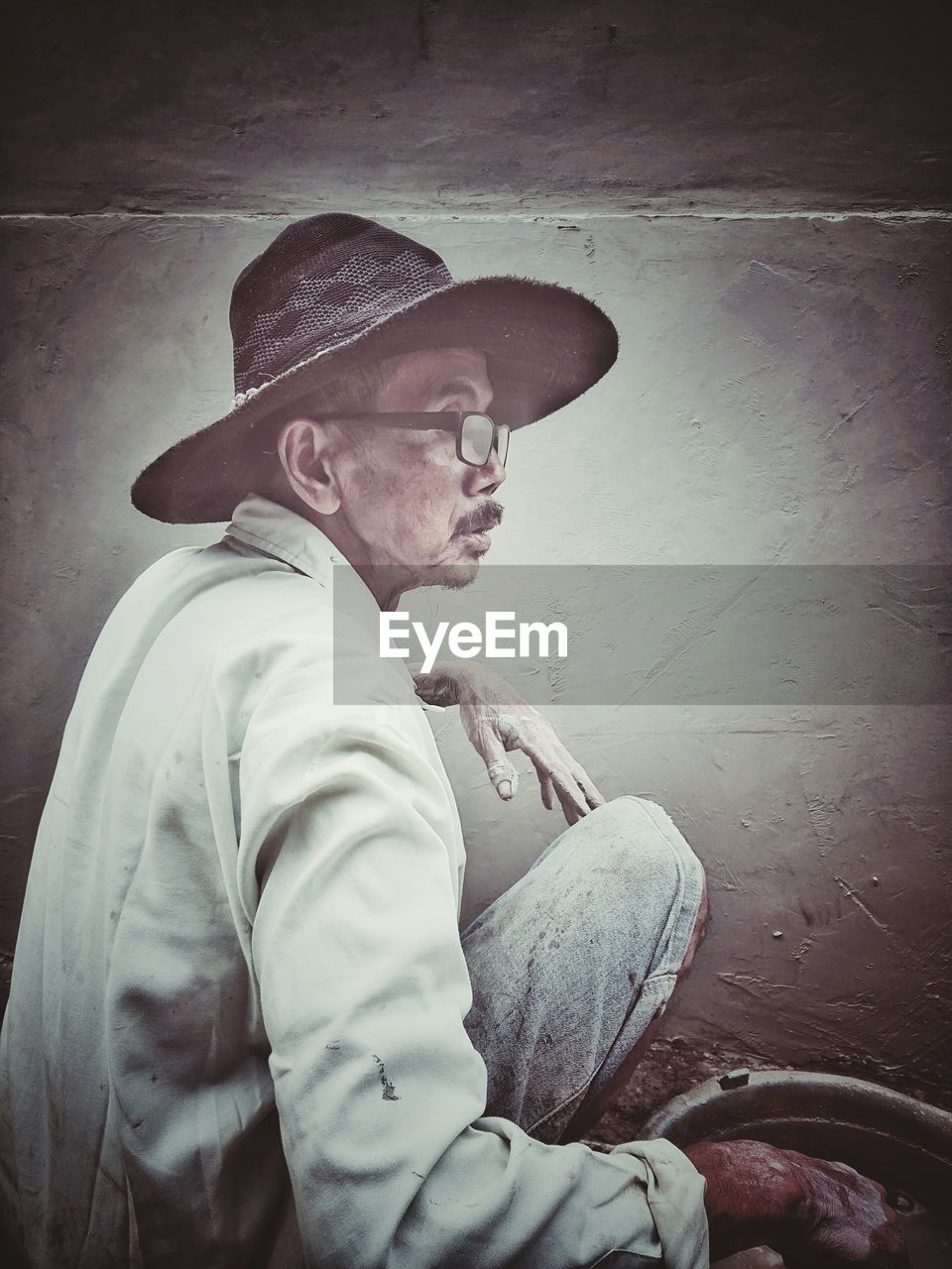 hat, adult, clothing, one person, men, cowboy hat, white, fedora, portrait, person, senior adult, vignette, black, fashion accessory, cowboy, sitting, contemplation, darkness, indoors, wall - building feature, sadness, sun hat