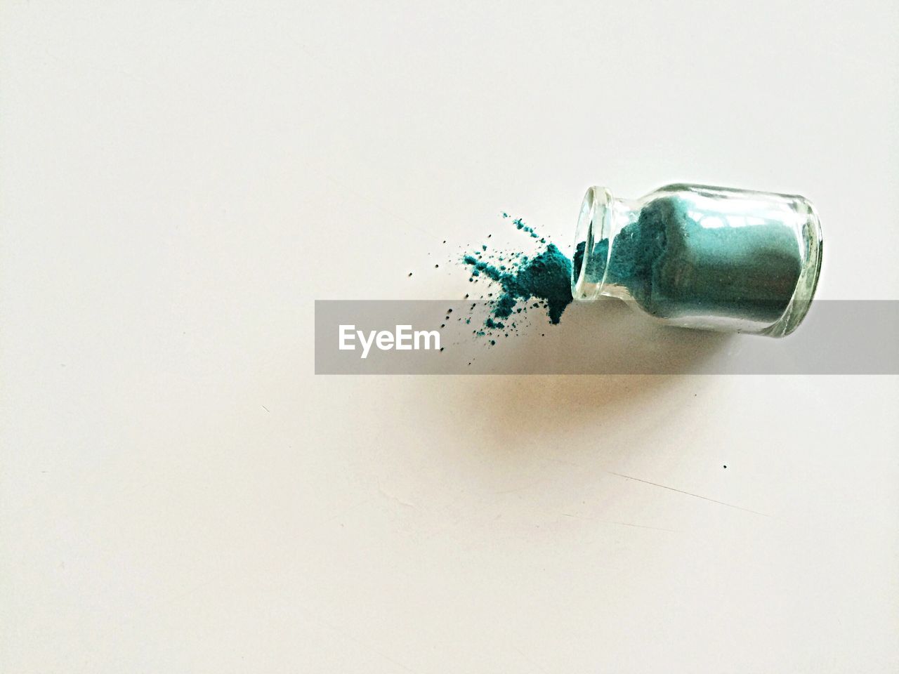 High angle view of green powder paint fallen from bottle