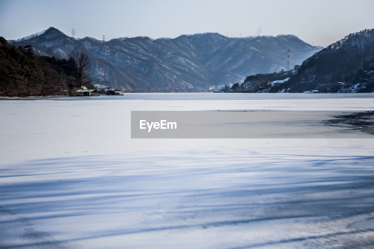 Scenic view of frozen beach against sky