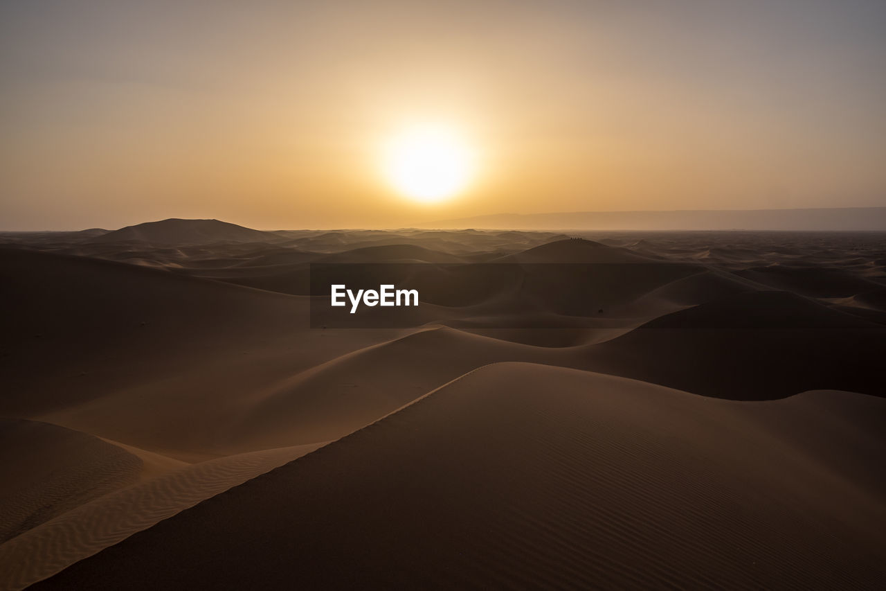 Erg chegaga, morocco - a sunset in the moroccan sahara desert, over an ocean of dunes.