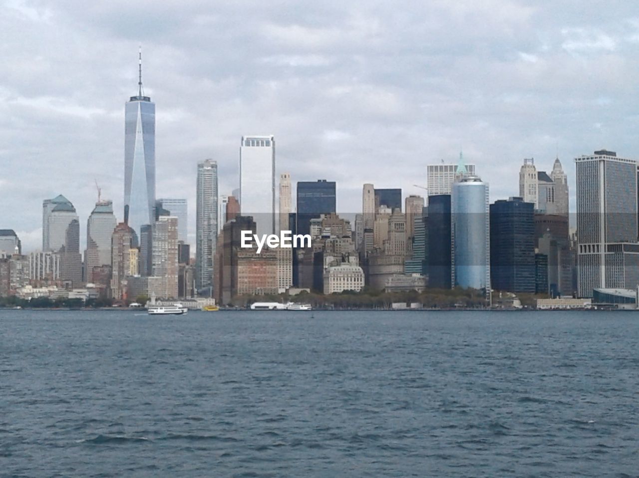 SEA BY MODERN BUILDINGS AGAINST SKY