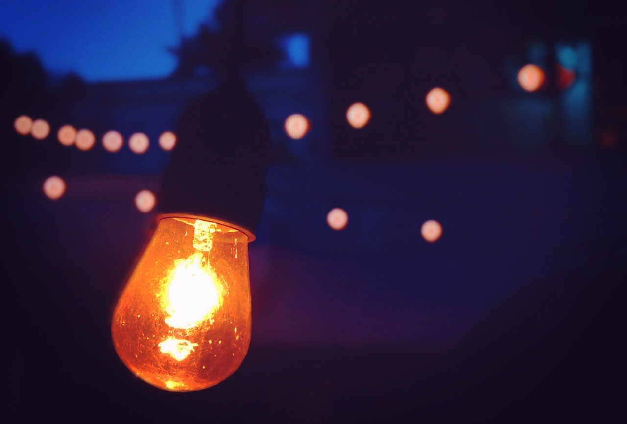 CLOSE-UP OF ILLUMINATED LIGHT BULB AT NIGHT