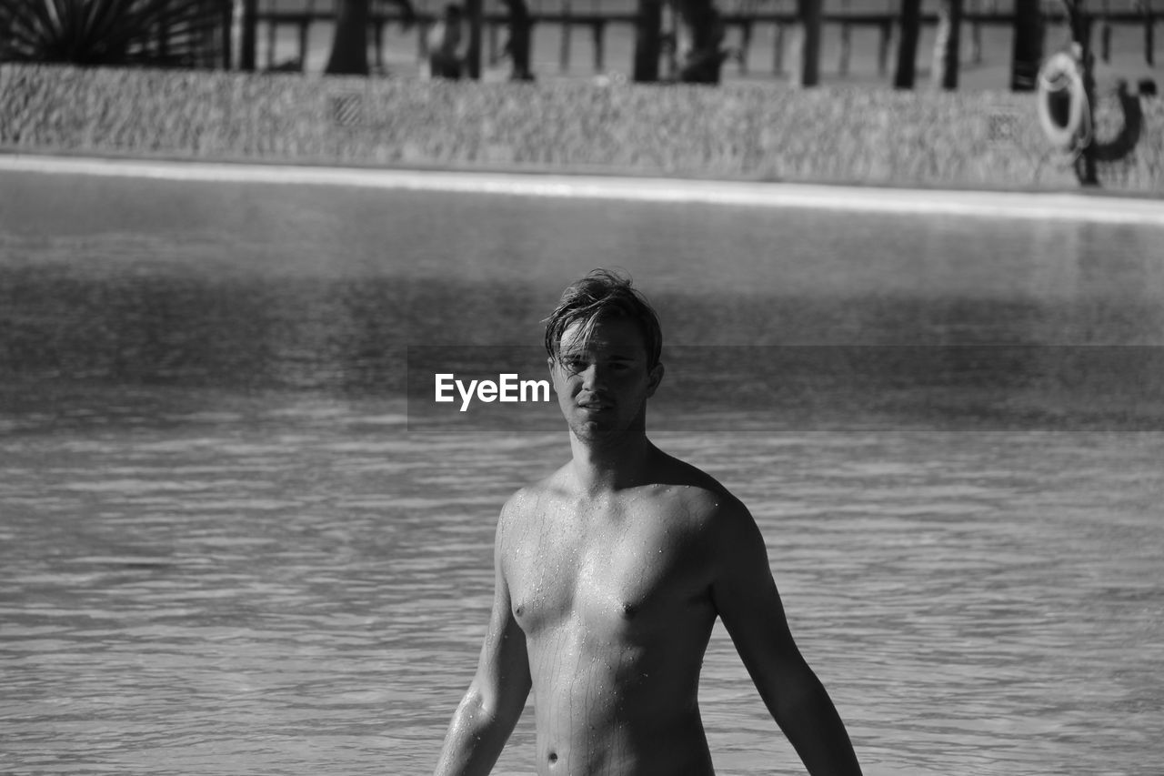 Portrait of shirtless man in lake