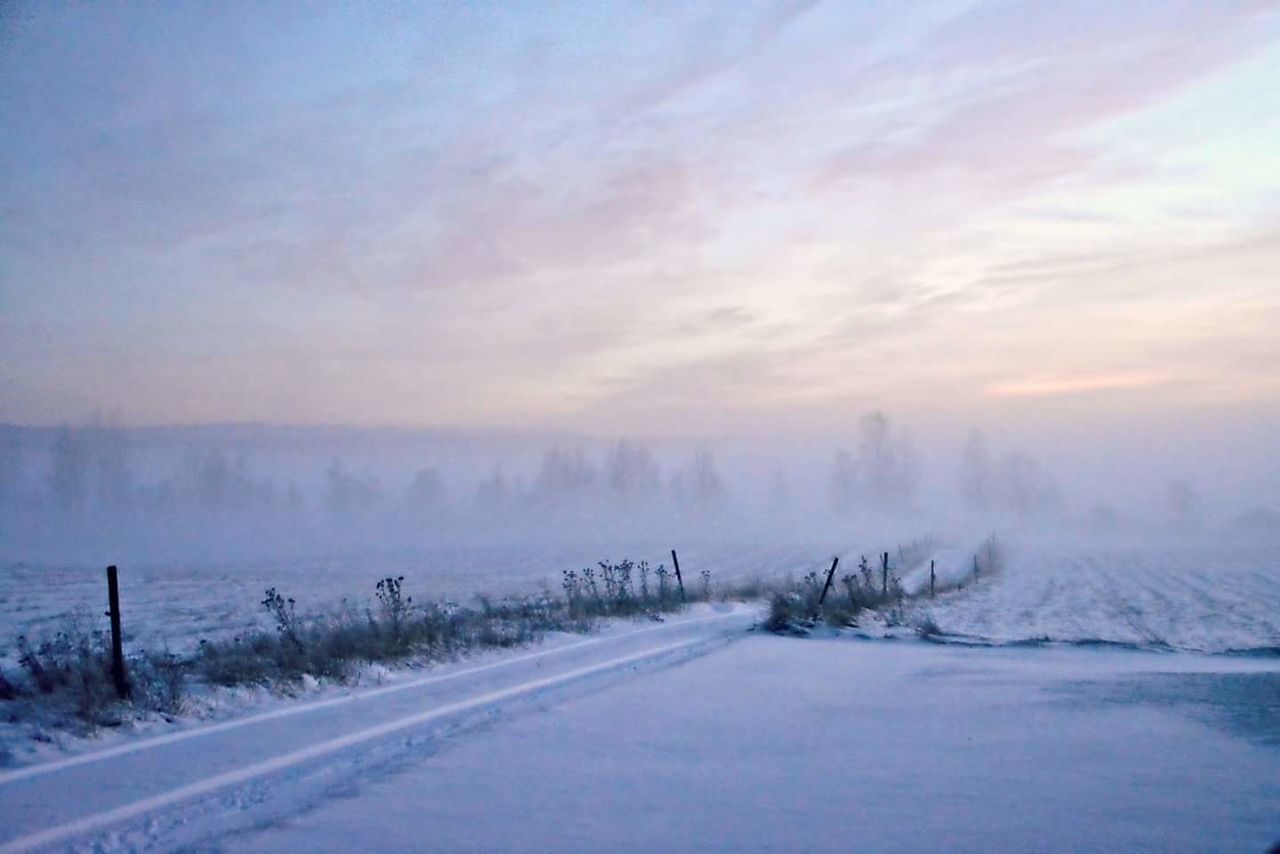 Road passing through snow covered landscape