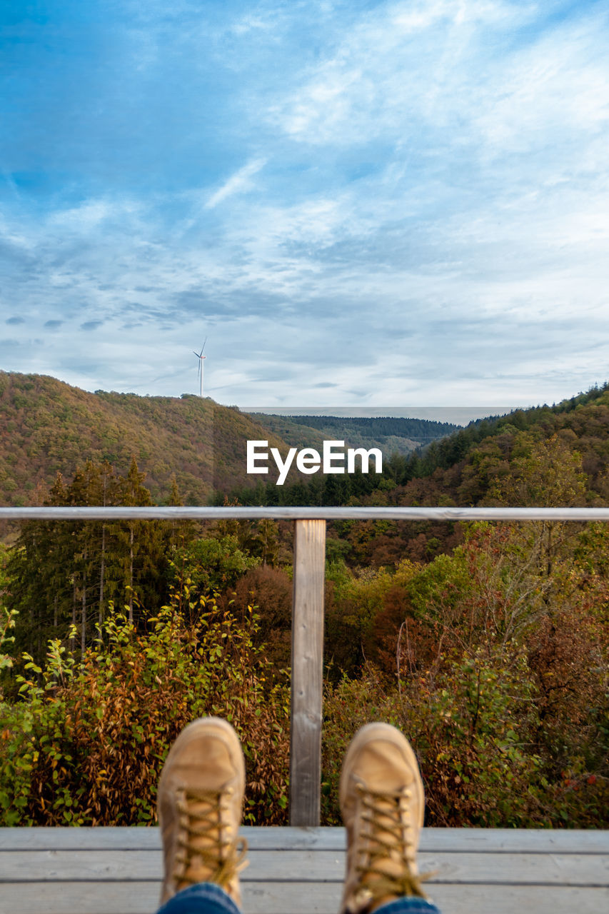 Low section of person sitting against mountains