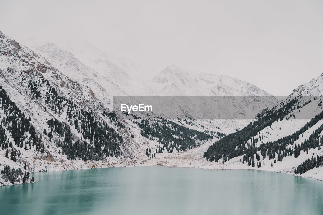 Scenic view of lake and snowcapped mountains against sky