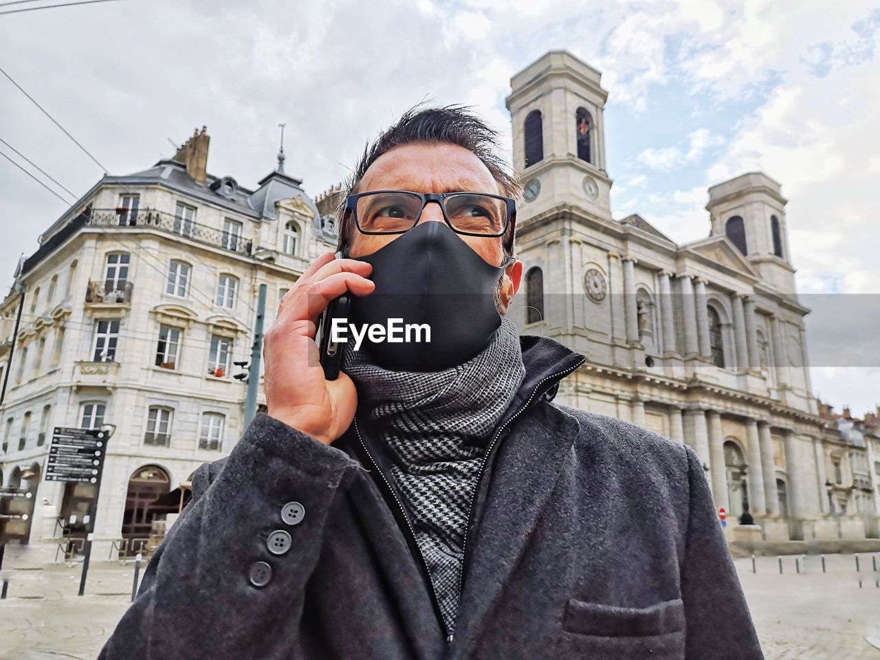 Portrait of man standing against building in city